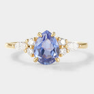 Pear-cut cornflower sapphire engagement ring with moissanite accents in yellow gold. Bridal set ring.